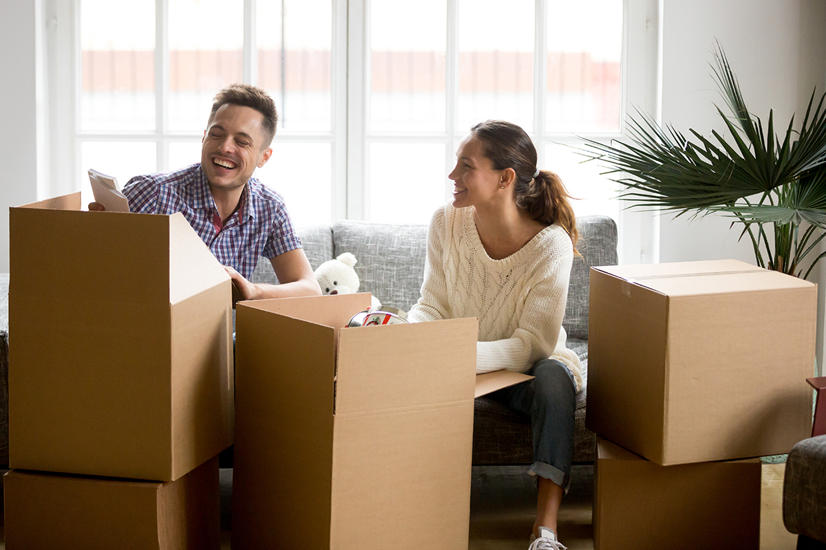 happy-couple-having-fun-laughing-unpacking-boxes-moving-day